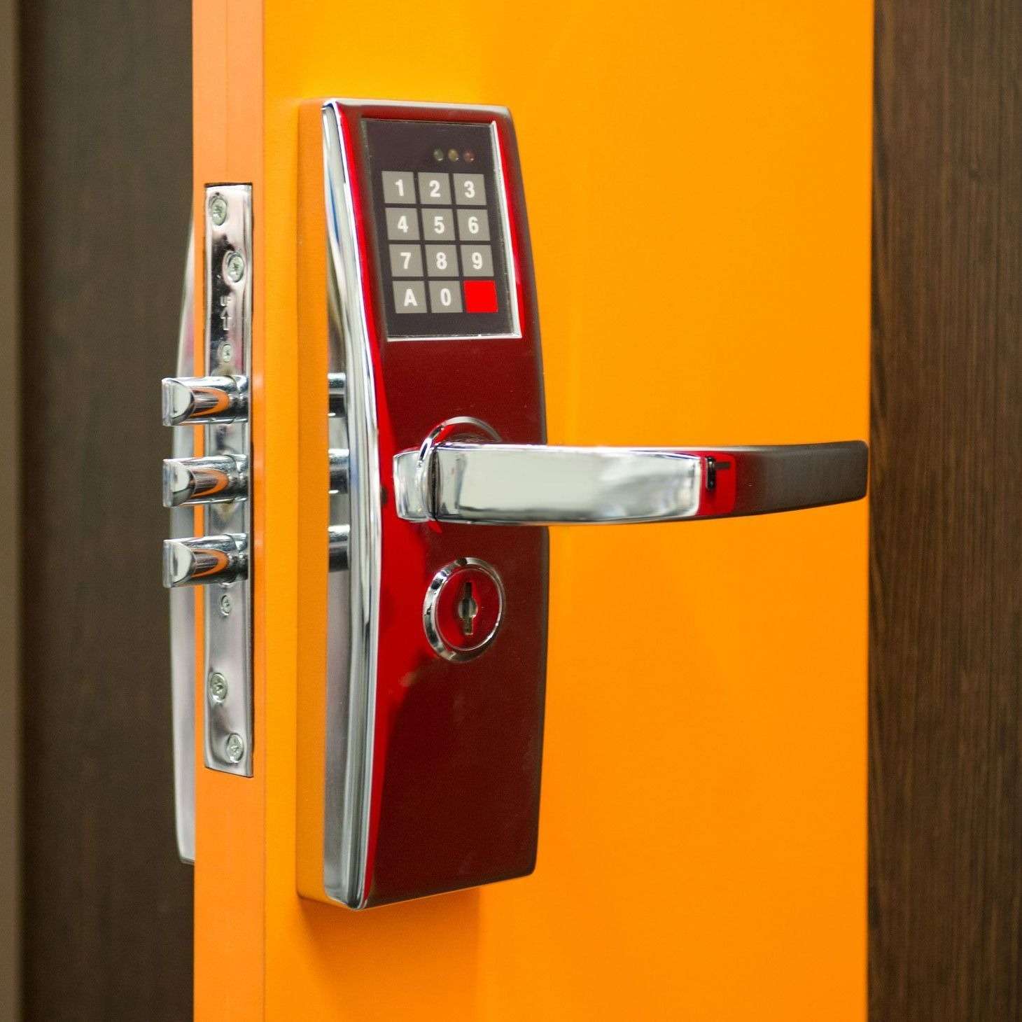 Digital keypad door lock on orange door