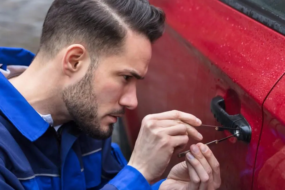 Locksmith picking car door lock.